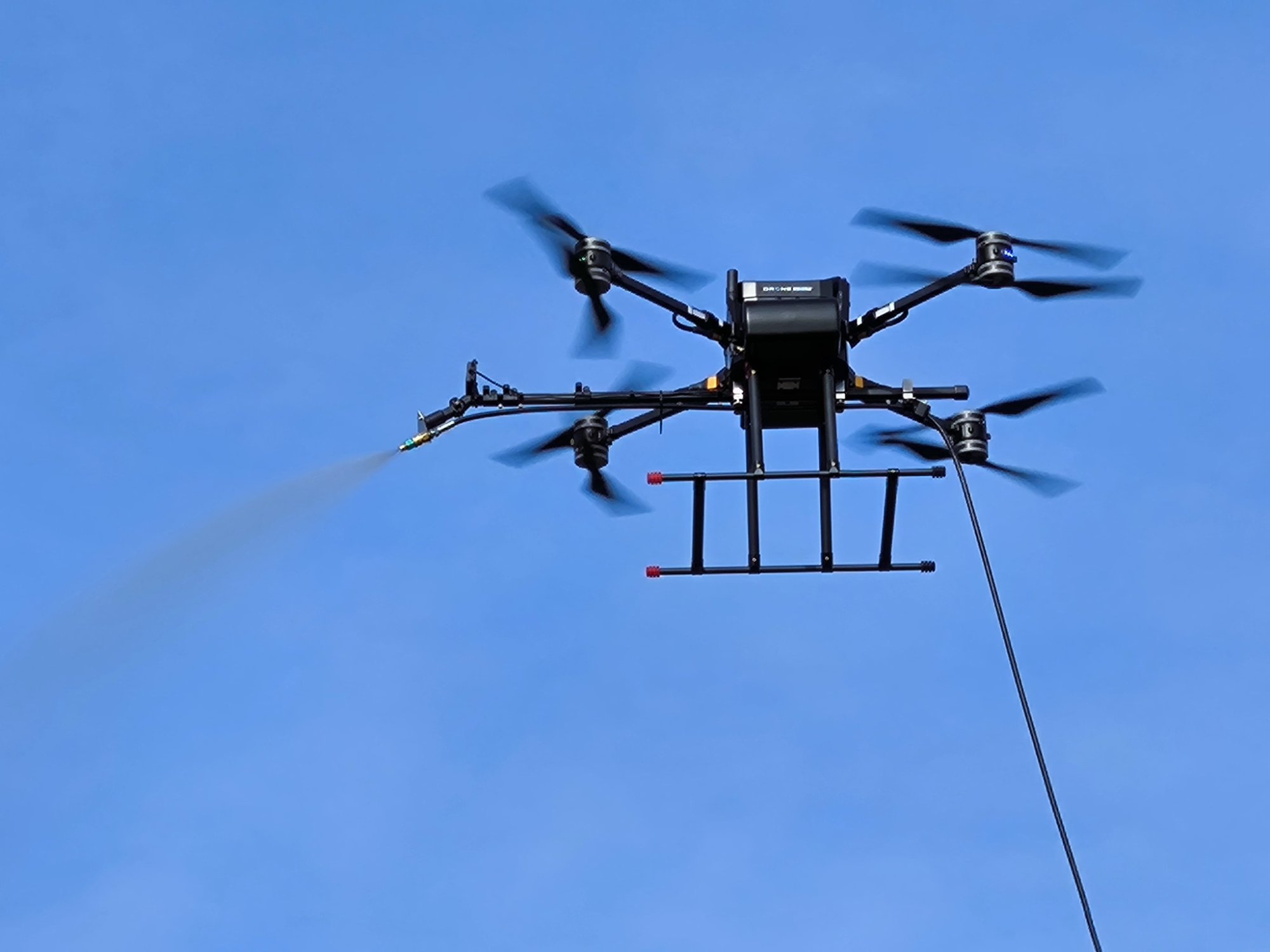 CleanAlta drone in action spraying water on building facade